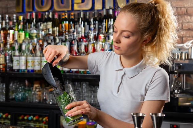 Woman bartender making an alcohol cocktail