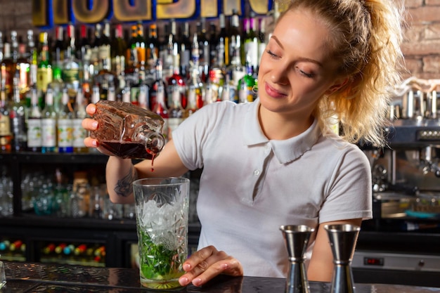 Woman bartender making an alcohol cocktail