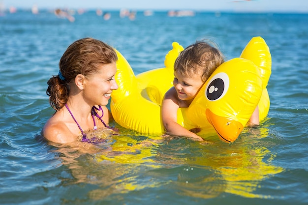 Woman bathing in the sea with a baby