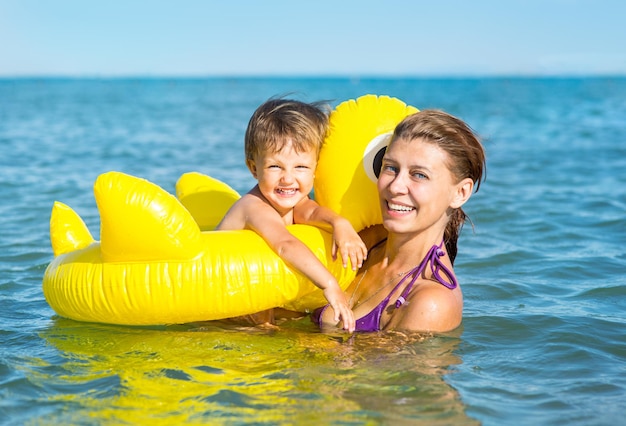 Woman bathing in the sea with a baby