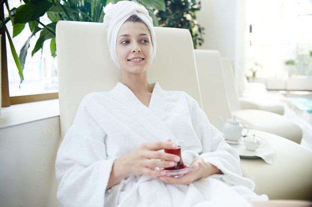 Woman in Bathrobe Relaxing by Pool in SPA