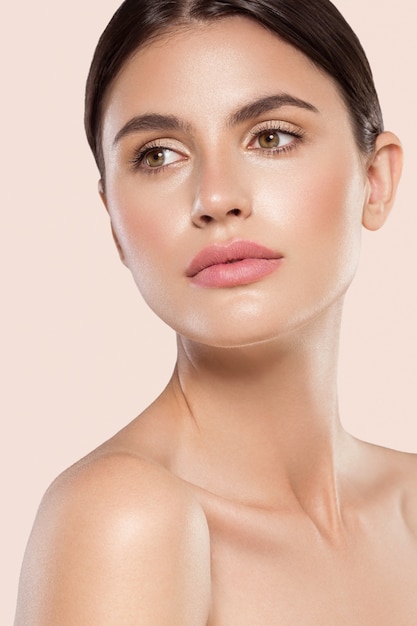 Woman beauty face healthy clean skin natural makeup beauty eyes female young model Beige background.