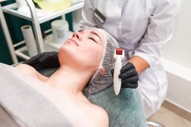 Woman in beauty salon during mesotherapy procedure with mesoscooter