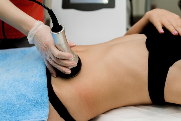 A woman in a beauty salon receives a vacuum abdominal massage Hardware cosmetology