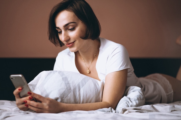 Woman in bed with phone