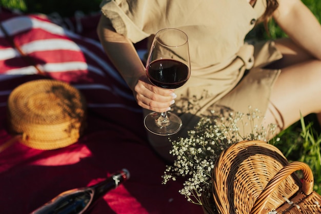 woman in beige dress holding a glass of red wine