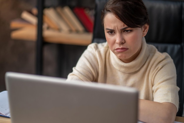 A woman in beige sweater looking tired and upset