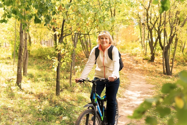 A woman on a Bicycle rides on the road in the city Park