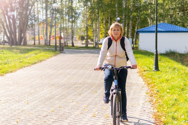 A woman on a Bicycle rides on the road in the city Park