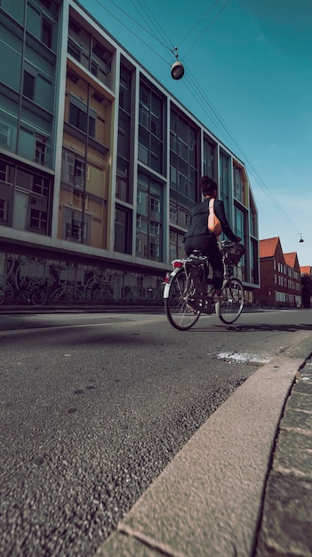 Woman on bike on the city street low angle rear view