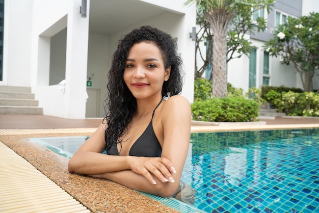 Woman in the bikini at pool Swimming pool tanned slim and shapely body Girl enjoying travel holidays at resort luxury overwater bungalow