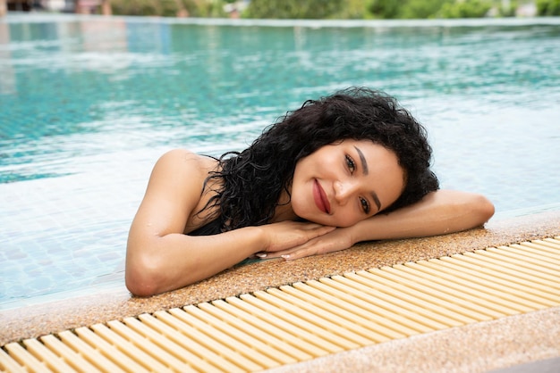 Woman in the bikini at pool Swimming pool tanned slim and shapely body Girl enjoying travel holidays at resort luxury overwater bungalow