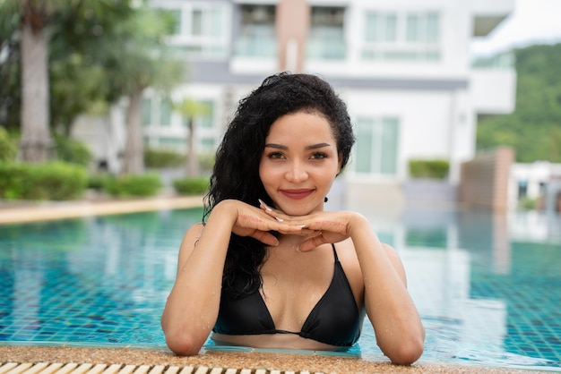 Woman in the bikini at pool Swimming pool tanned slim and shapely body Girl enjoying travel holidays at resort luxury overwater bungalow