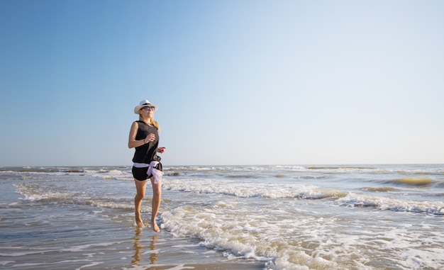 woman in bikini running on the shore