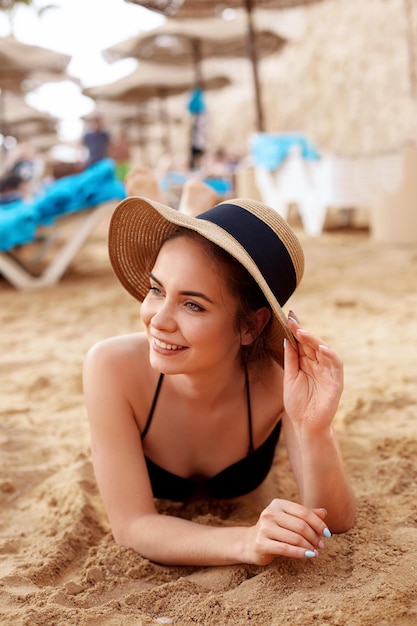 Woman in bikini and sun hat relaxing at sunny beach remote tropical beaches