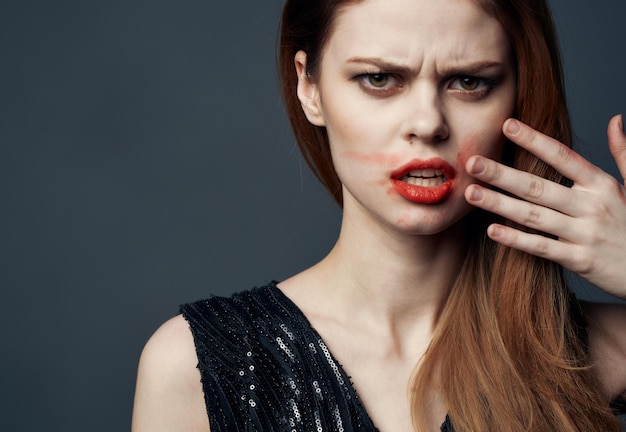 Woman in black dress touching face with hands and lipstick stress irritability