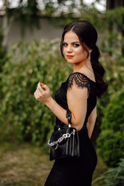 A woman in a black dress with a bag that says'chanel'on it