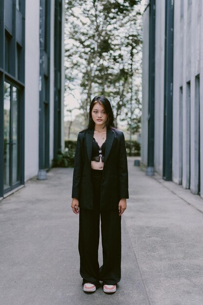 A woman in a black jacket stands in a hallway.