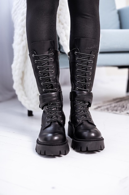 Woman in black leather boots from the new collection. Woman's legs in stylish autumn-winter leather boots.