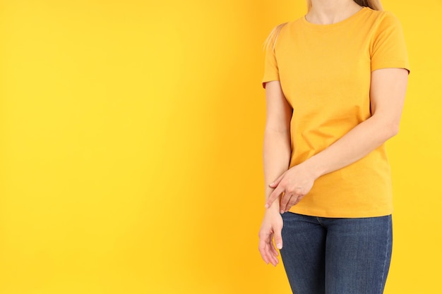 Woman in blank orange t-shirt on yellow background