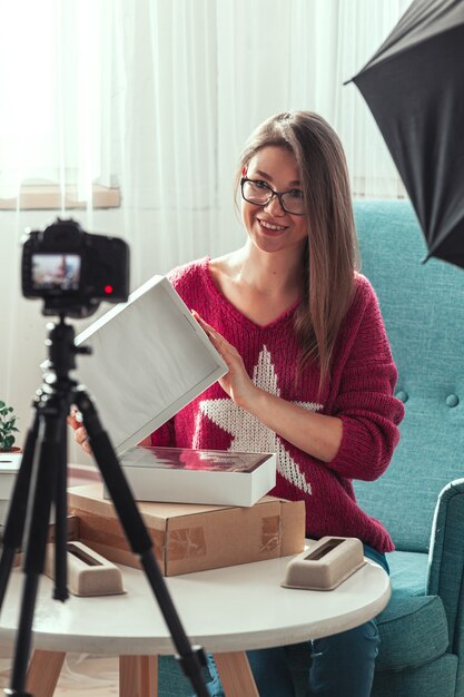 Photo woman blogger makes video of unpacking gadgets at home