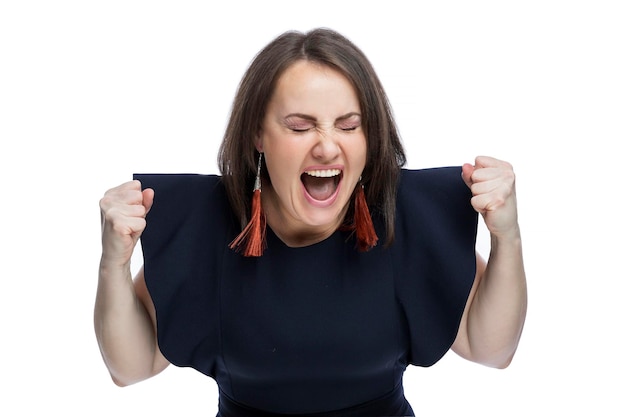 A woman in a blue dress screams with her hands clenched into fists Anger and aggression Isolated on white background Closeup