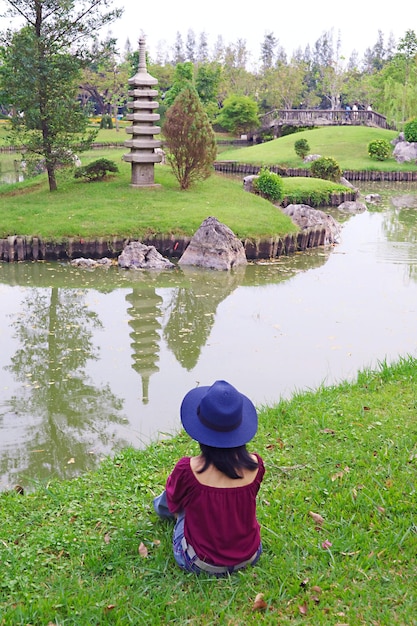 Woman in Blue Hat Relaxing in a Gorgeous Japanese Garden