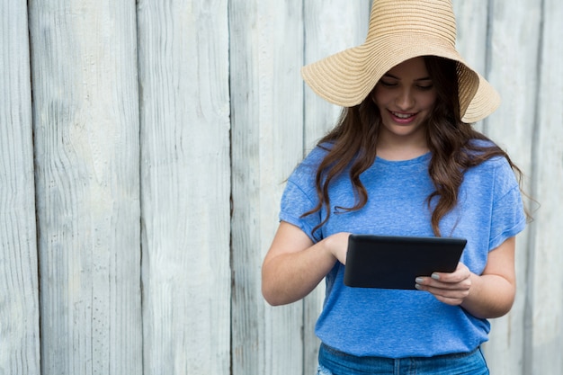 Woman in blue top and hat using digital tablet