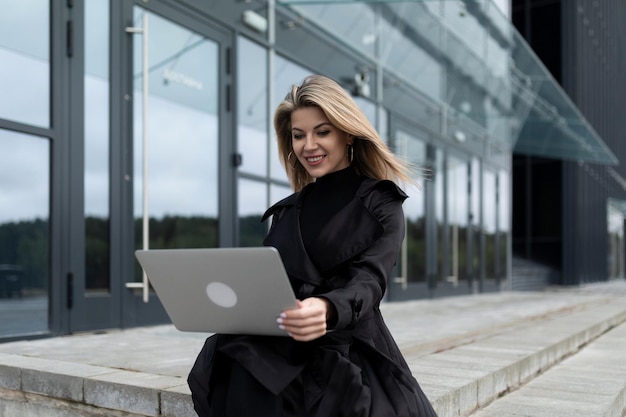 Woman boss working on laptop at office entrance