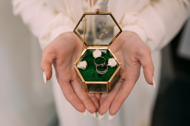 Woman bride holding wedding rings in a box on her hands