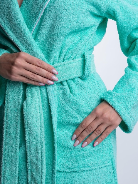 Woman in a bright dressing gown advertises clothing details on an isolated white background