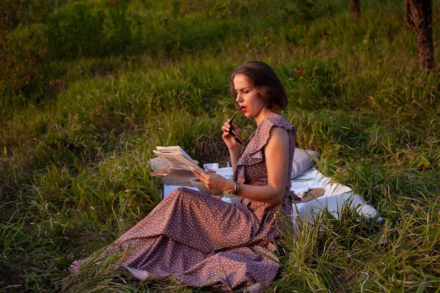 A woman in brown dress sits on a picnic in a park with panoramic view