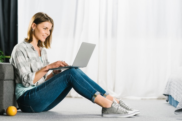 Woman browsing laptop on floor