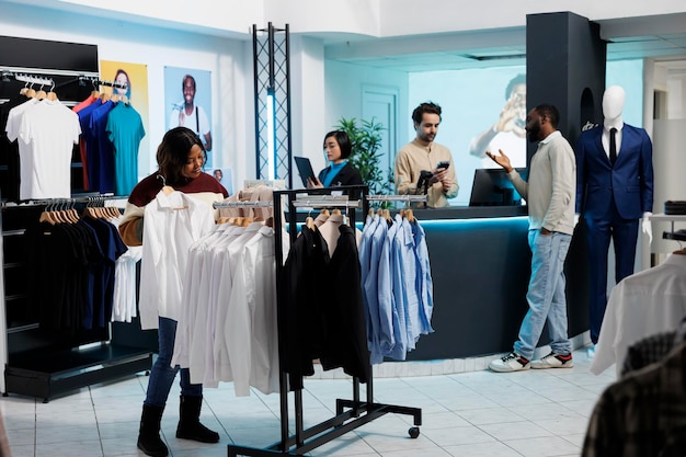 Woman browsing rack with shirts in store