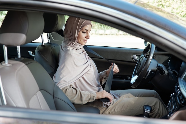 Woman buckling seat belt