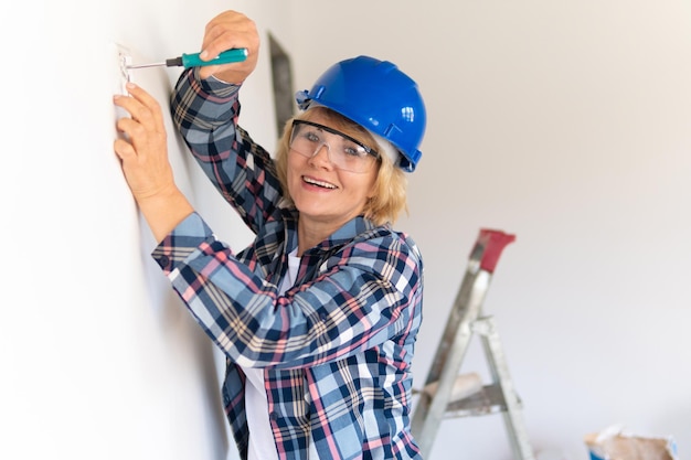 Woman Builder in the room of the house making repairs