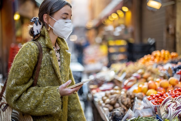 Woman buying food on the street market during pandemic