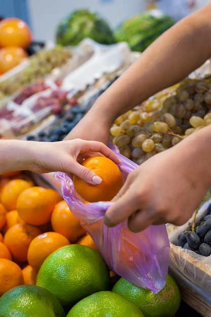 Woman buying fresh vegetables at street market