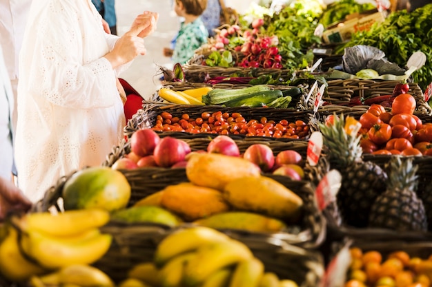 Woman buying vegetables and fruit at farmers market