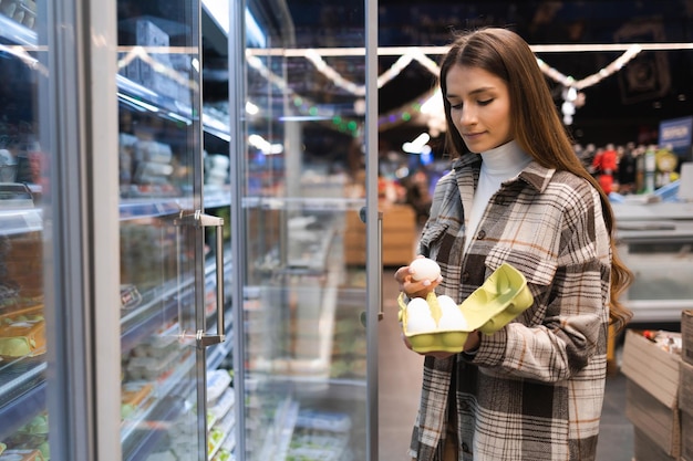 Woman buys chicken eggs in supermarket