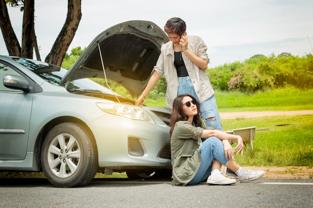 Woman calling the roadside service/assistance after her car has broken down