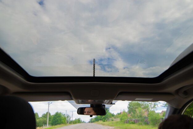 Woman car driver eyes reflection in mirror sunroof copy space