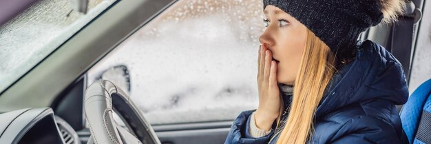 Woman in a car during a snowfall problems on the road banner long format