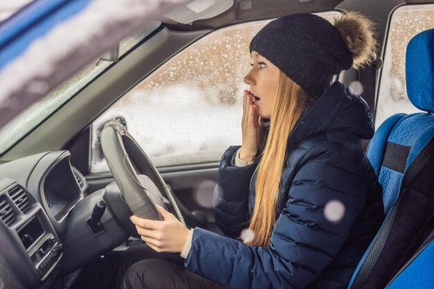 Woman in a car during a snowfall problems on the road