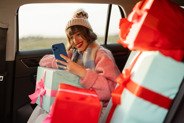 Photo woman in car with christmas presents