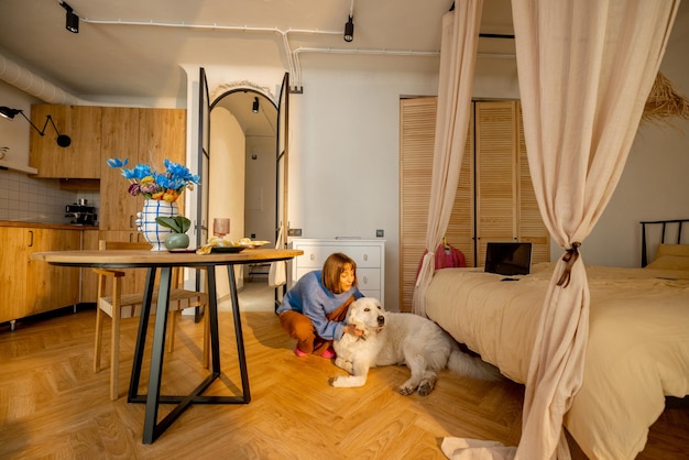 Woman cares her dog at modern studio apartment