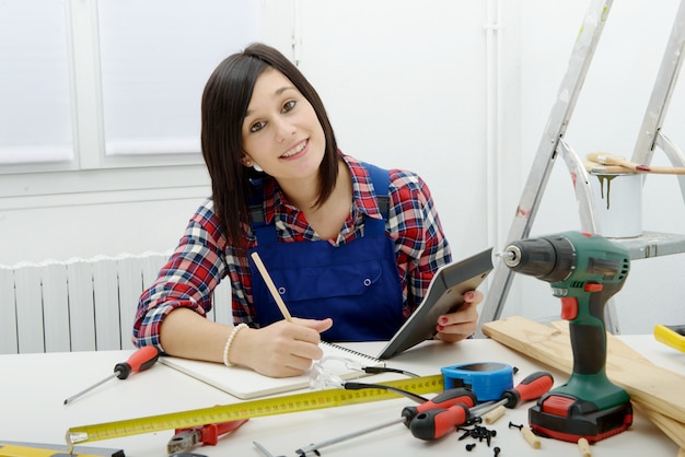 Woman carpenter sitting at desk in her workshop