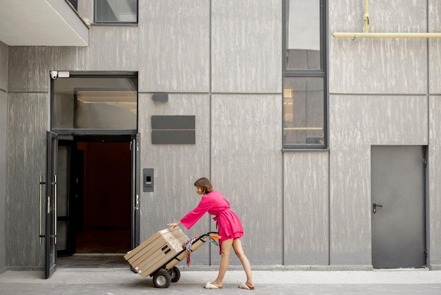 Woman carries furniture in boxes on a cart