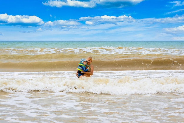 A woman carries in her arms a child from a stormy sea