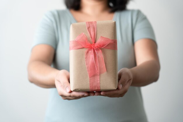 Woman carrying gift paper box tie cute ribbon for special occasion